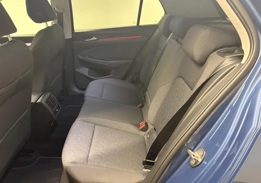 Vue intérieure arrière côté droit de la Volkswagen Golf 1.5 eTSI 116 DSG7 Bleu Anémone, montrant les sièges tissu et les ceintures.