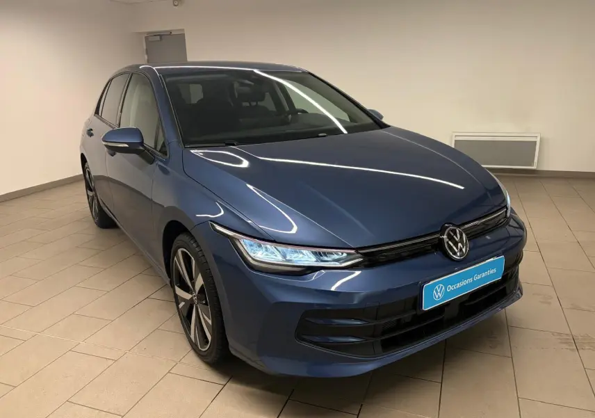Volkswagen Golf 1.5 eTSI 116 DSG7 Bleu Anémone vue 3/4 avant avec jantes alliage 18'' Catania en intérieur showroom.