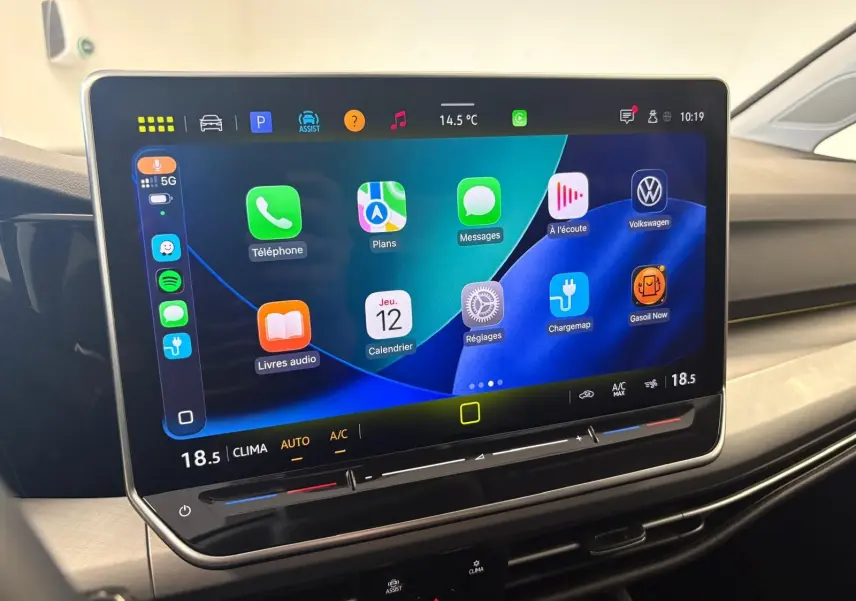 Écran tactile central de la Volkswagen Golf 2025 affichant les applications connectées et la climatisation à 18,5°C.