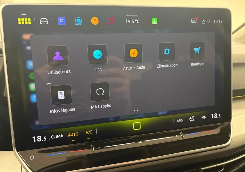 Vue de face du tableau de bord tactile de la Volkswagen Golf 1.5 eTSI 116 DSG7 VW Edition avec interface climatisation et aides.