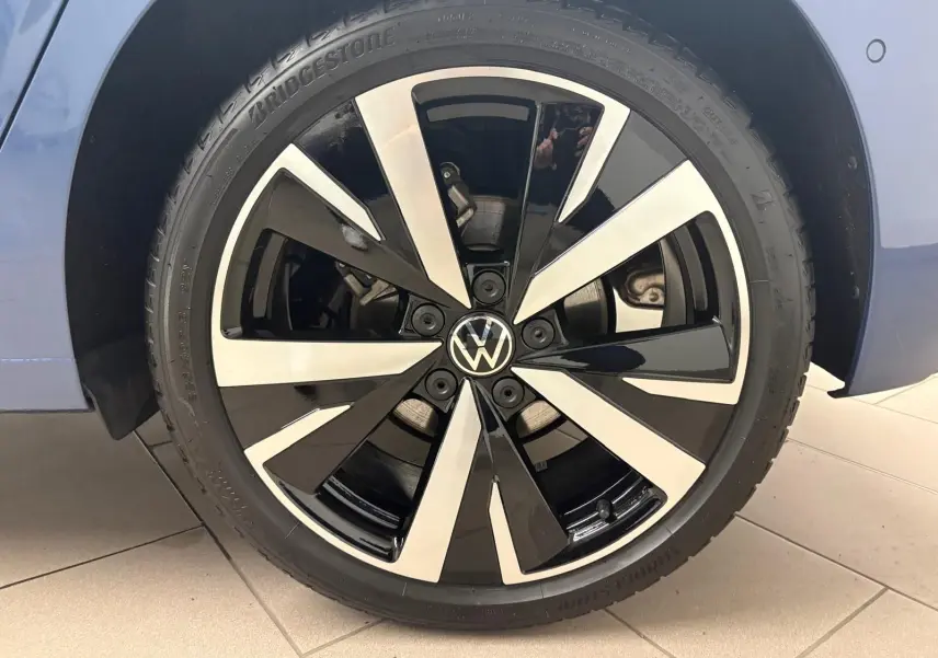 Gros plan sur la jante alliage 18'' Catania bicolore noir et argent d'une Volkswagen Golf Bleu Anémone.