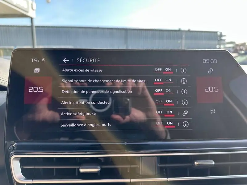 Écran tactile intérieur du Citroën C5 Aircross 2025 affichant les options de sécurité, avec reflets et tableau de bord noir.