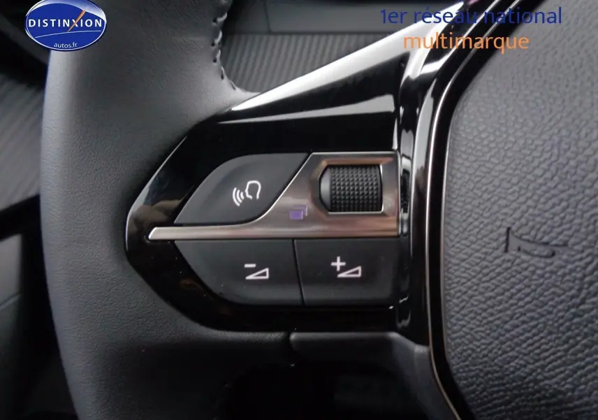 Gros plan sur les commandes du volant côté gauche du Peugeot 2008 rouge Elixir Metal, version 2023.