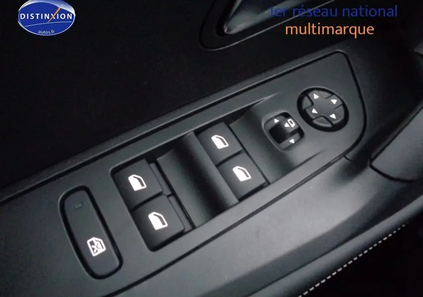 Gros plan sur les commandes des vitres électriques et réglages des rétroviseurs côté conducteur d'un Peugeot 2008 rouge Elixir Metal.