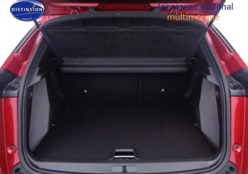 Coffre ouvert vu de l'arrière d'un Peugeot 2008 rouge Elixir Metal, montrant l'espace de chargement vide.