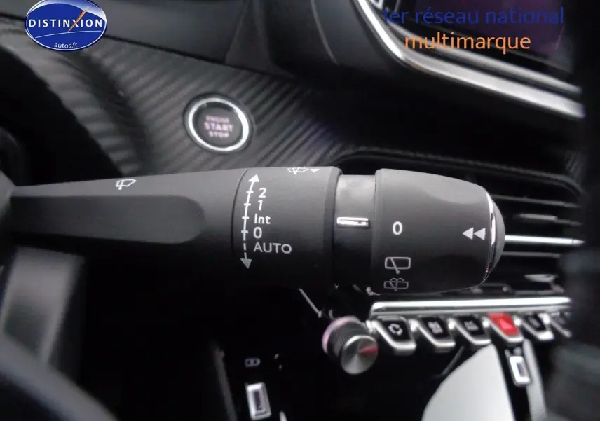 Gros plan sur la commande d’essuie-glace du Peugeot 2008 rouge Elixir Metal, avec bouton start visible en arrière-plan.
