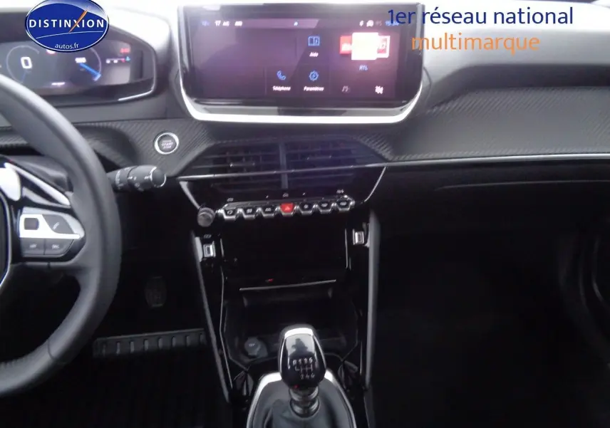 Intérieur Peugeot 2008 rouge Elixir, vue centrée sur la console avec levier de vitesse manuel et écran tactile.