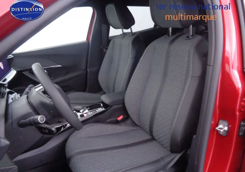 Intérieur avant droit d'une Peugeot 2008 rouge Elixir Metal avec sièges tissu gris et console centrale moderne.