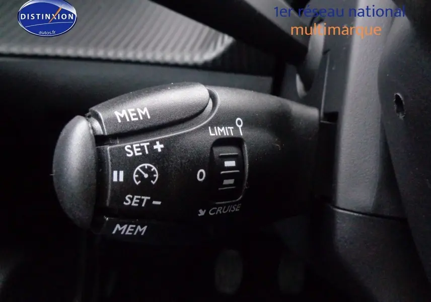 Gros plan sur la commande de régulateur de vitesse du Peugeot 2008 rouge Elixir Metal, version 2023.