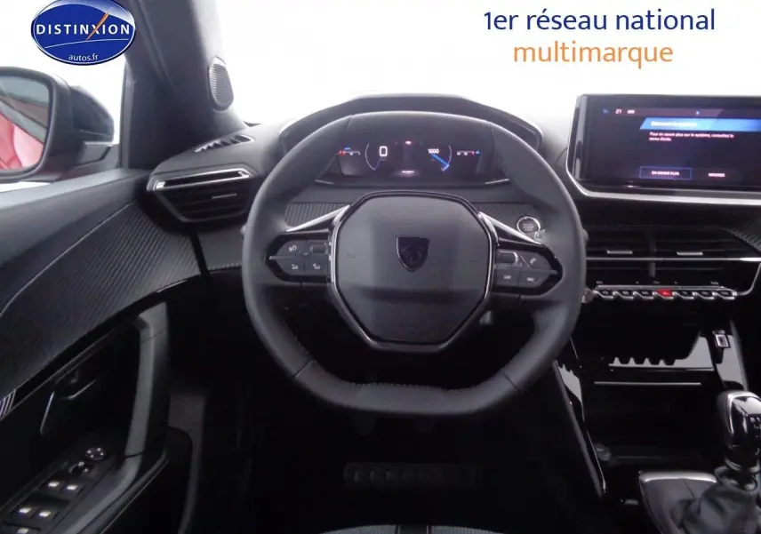 Vue intérieure centrée sur le volant compact et le tableau de bord numérique d'une Peugeot 2008 rouge Elixir Metal.