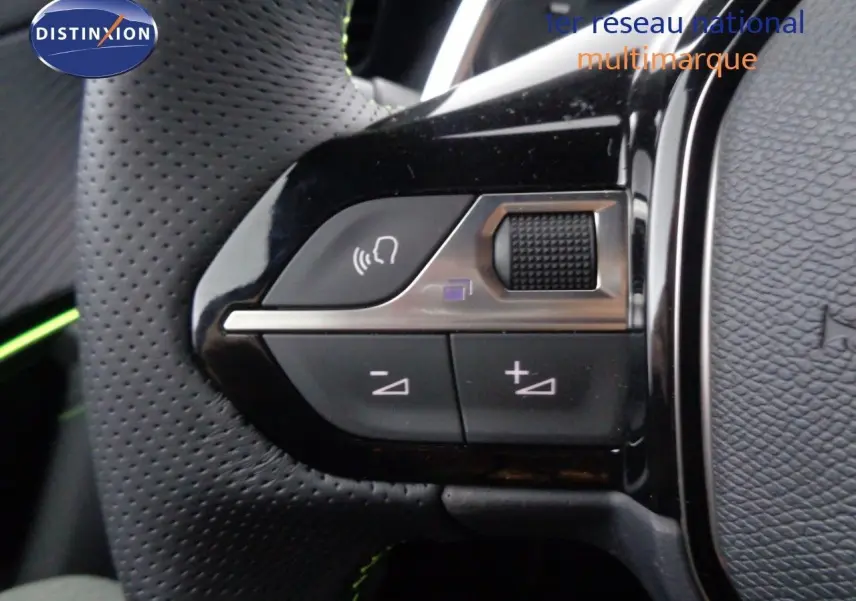 Gros plan sur les commandes vocales et volume du volant en cuir perforé noir du Peugeot 2008 GT 2023.