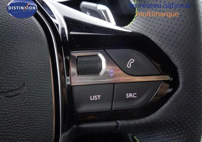 Gros plan sur les commandes du volant en cuir perforé noir de la Peugeot 2008 GT gris Artense métal avec toit noir.