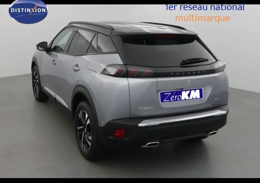 Vue 3/4 arrière d'un Peugeot 2008 gris Artense métal avec toit noir, feux LED et double sortie d'échappement chromée.