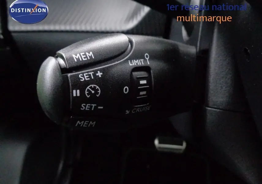 Gros plan sur la commande de régulateur de vitesse du Peugeot 2008 gris Artense métal avec toit noir, version 2023.