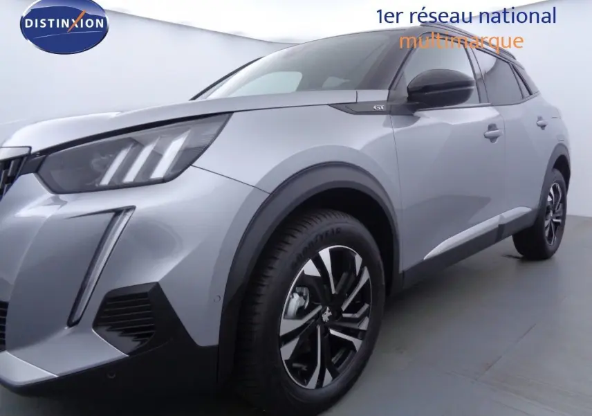 Peugeot 2008 GT gris Artense métal avec toit noir, vue 3/4 avant droit mettant en valeur ses phares LED et jantes biton.