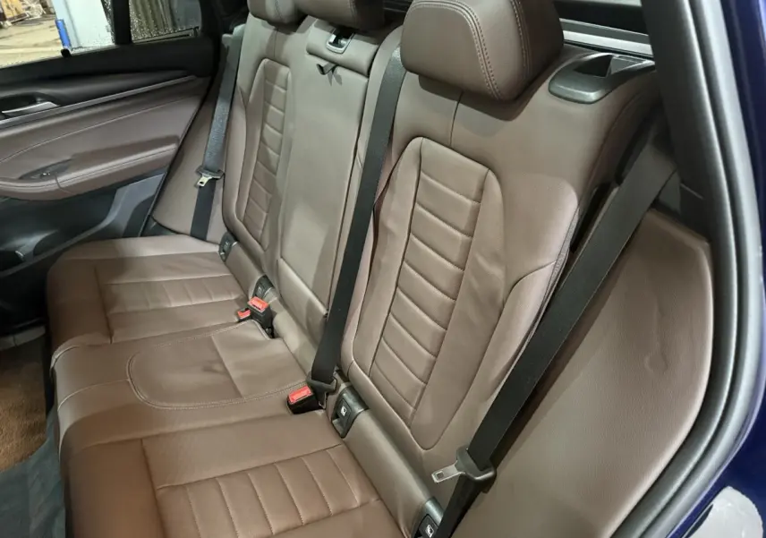 Vue intérieure côté droit montrant la banquette arrière en cuir marron du BMW X3 xDrive30e bleu 2023.