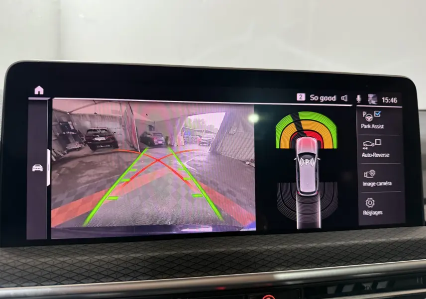 Écran central affichant la caméra de recul et l'assistance au stationnement du BMW X3 bleu hybride rechargeable 2023.