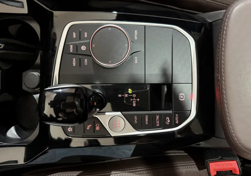 Vue rapprochée de la console centrale noire et brun cuir du BMW X3 xDrive30e avec levier de vitesses et commandes hybrides.