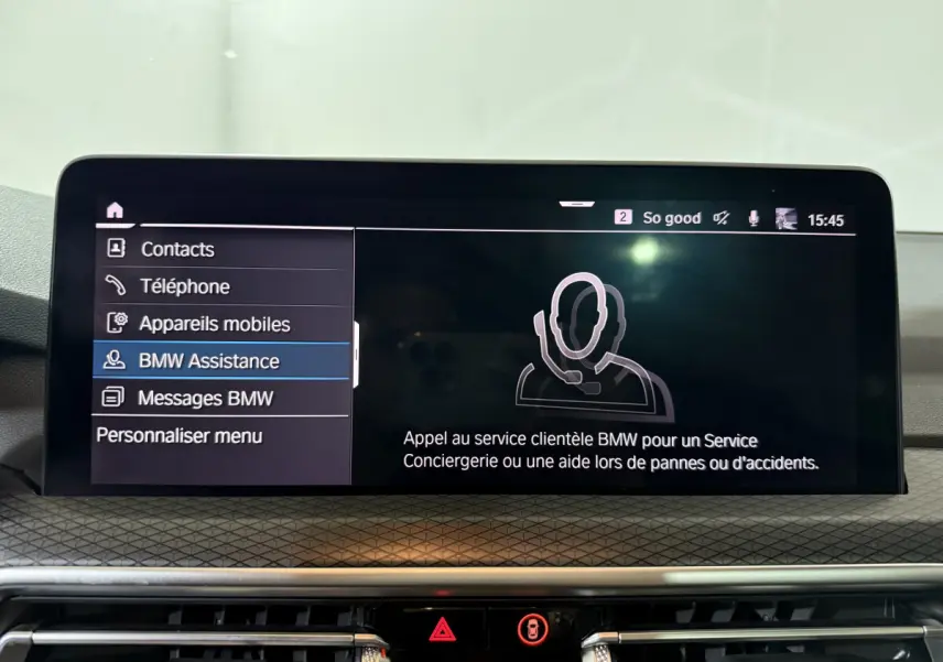 Écran tactile central du BMW X3 xDrive30e 2023 affichant le menu BMW Assistance en intérieur.