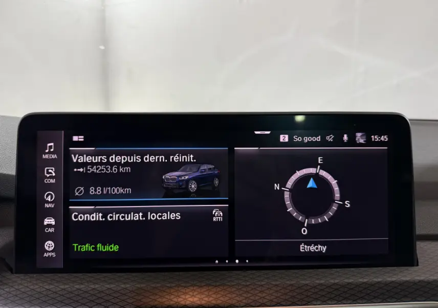 Écran tactile central du tableau de bord montrant les infos de consommation et navigation d'un BMW X3 bleu.