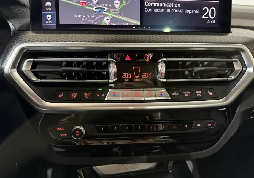 Tableau de bord central de BMW X3 xDrive30e 2023 avec écran tactile et commandes climatisation en gros plan.