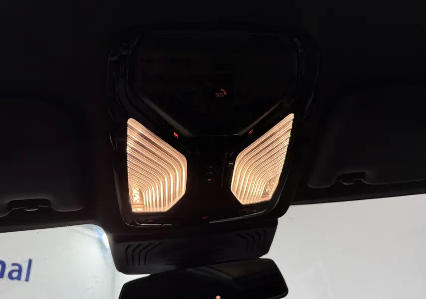 Plafonnier intérieur éclairé avec bouton SOS rouge, vue depuis l'habitacle du BMW X3 xDrive30e bleu 2023.