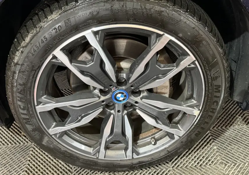 Gros plan sur la jante alliage BMW M Sport avec pneu Michelin, détails du disque de frein visibles.