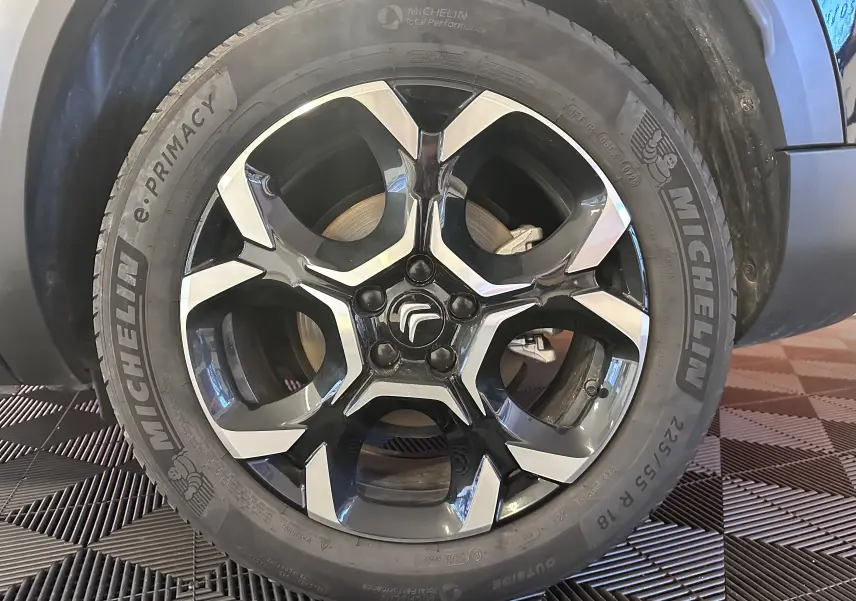 Gros plan sur la jante alliage 18 pouces biton et pneu Michelin du côté avant droit d’un Citroën C5 Aircross noir hybride.