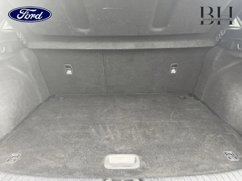 Coffre vu de l'intérieur, tapis noir et surfaces textiles sombres, sans objet visible ni éléments distinctifs apparents.