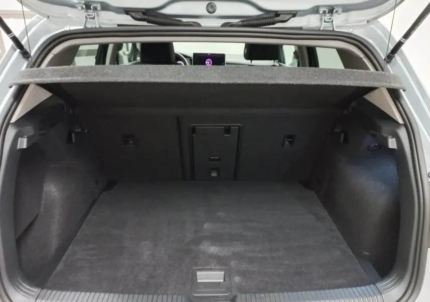 Vue arrière du coffre ouvert d'une Volkswagen Golf 1.5 eTSI 2025 en Argent Dolomite, montrant l'espace de chargement vide.
