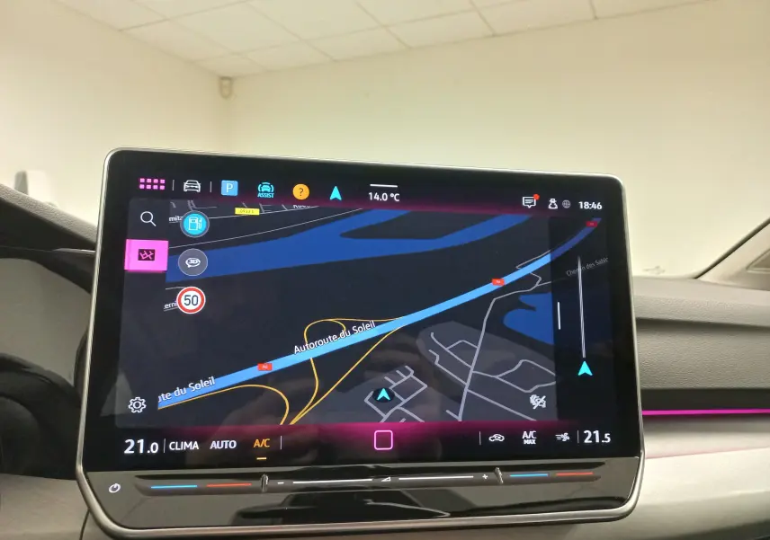 Vue intérieure du tableau de bord de la Volkswagen Golf 2025 avec écran tactile affichant la navigation et climatisation digitale.