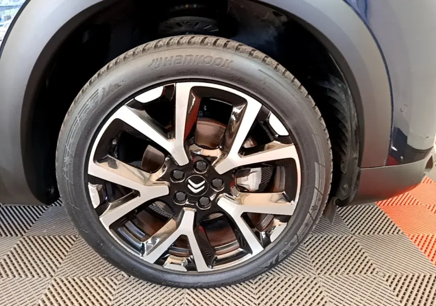 Gros plan sur la roue avant droite noire et argentée du Citroën C5 Aircross 2023, avec logo Citroën visible.
