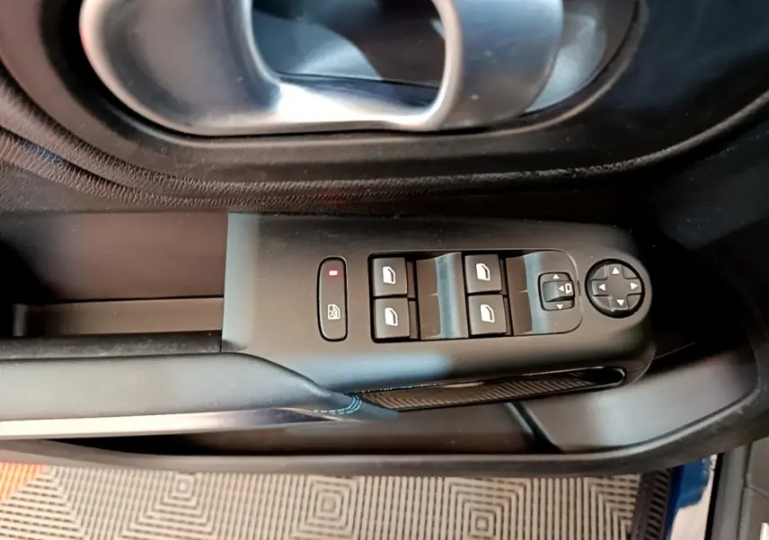 Vue rapprochée du panneau de commandes des vitres et rétroviseurs côté conducteur d'un Citroën C5 Aircross 2023, intérieur noir.