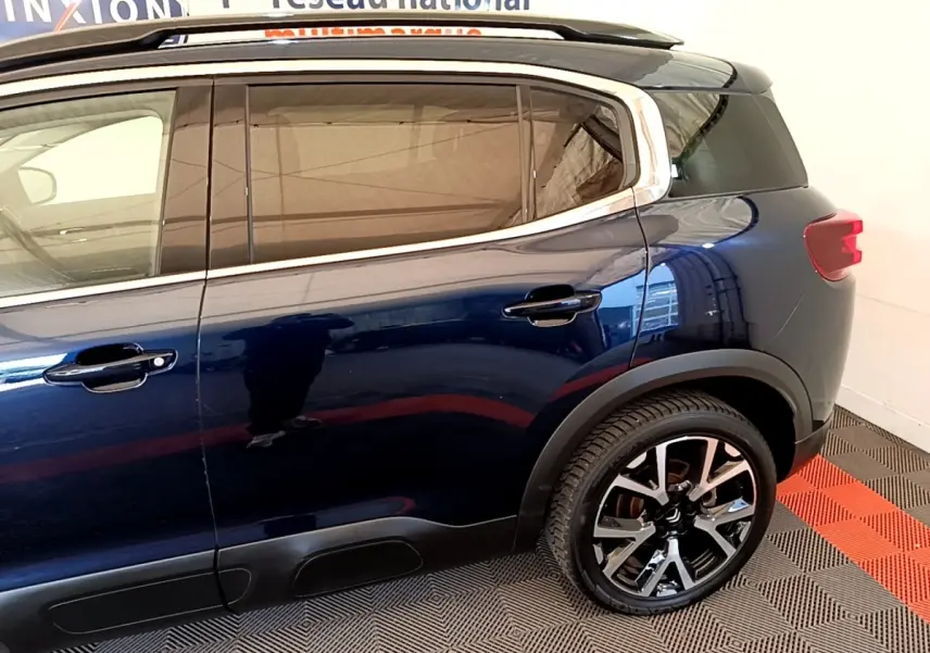 Vue latérale droite du Citroën C5 Aircross bleu foncé avec jantes alliage et protections noires sur bas de caisse.