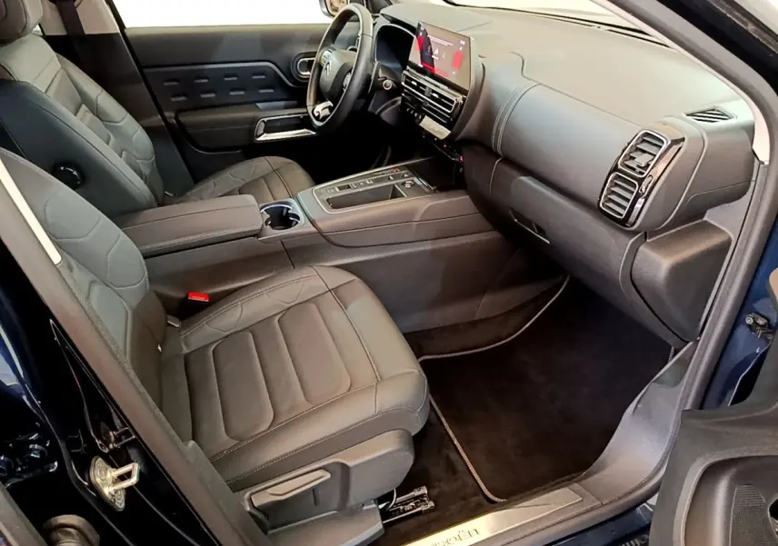 Vue intérieure côté passager avant du Citroën C5 Aircross 2023 avec sièges cuir noirs et tableau de bord digital.