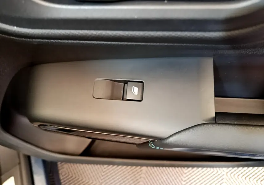 Gros plan sur le bouton de commande de la vitre électrique côté conducteur du Citroën C5 Aircross 2023, intérieur noir.