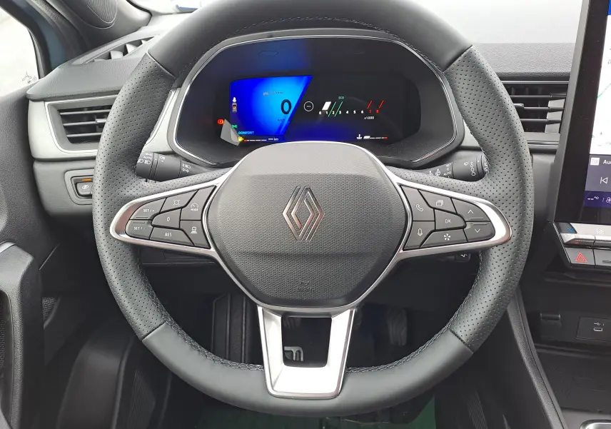 Vue rapprochée du volant en cuir perforé noir et du tableau de bord numérique du Renault Symbioz bleu Mercure 2025.