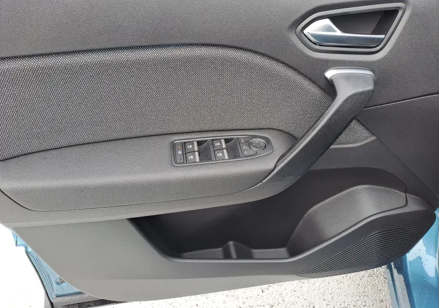 Vue intérieure côté gauche de la porte avant d'une Renault Symbioz bleu mercure, avec commandes de vitres et poignée noire.