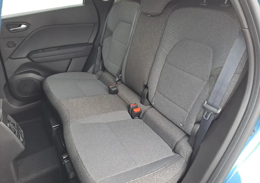 Vue intérieure côté droit sur les sièges arrière gris du Renault Symbioz bleu Mercure, montrant les ceintures et la porte ouverte.