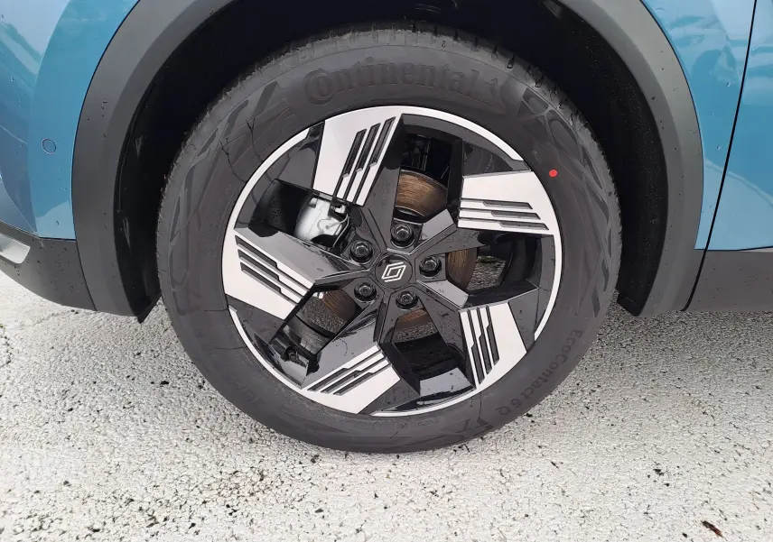 Gros plan sur la roue avant droite bleu mercure d'une Renault Symbioz 2025 avec jante noire et argentée au design géométrique.