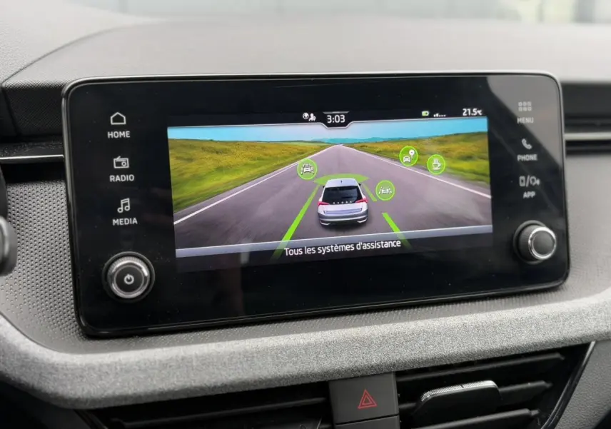 Écran tactile central affichant l'aide à la conduite du Skoda Scala blanc Candy, vue intérieure du tableau de bord.