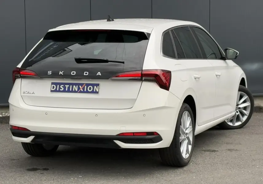 Vue 3/4 arrière droite d'une Skoda Scala blanc Candy avec jantes alliage 17 pouces et feux arrière LED distinctifs.