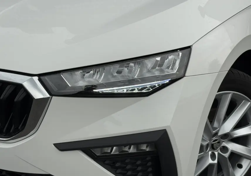 Gros plan sur l'avant droit blanc Candy d'une Skoda Scala 2024, mettant en valeur le phare et la jante alliage 17 pouces.