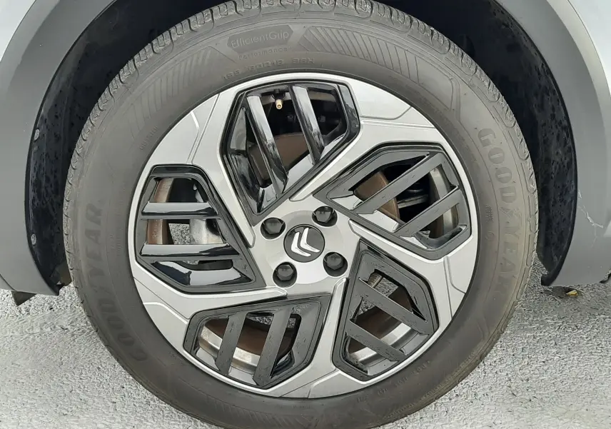 Gros plan sur la roue avant droite d'une Citroën C4 gris acier 2024 avec jante alliage au design géométrique bicolore.