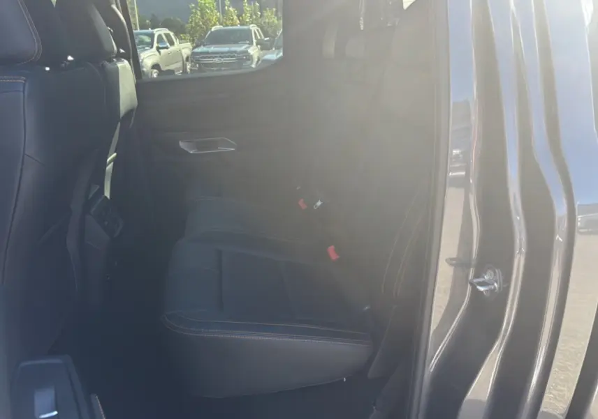 Vue intérieure côté droit sur les sièges arrière en cuir noir avec surpiqûres orange du Ford Ranger Wildtrak gris carbone 2025.