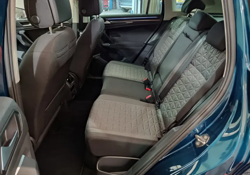 Vue côté droit de l'intérieur arrière du Volkswagen Tiguan bleu 2022 avec sièges tissu à motif géométrique.