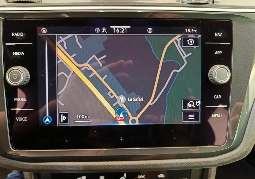 Écran tactile central du Volkswagen Tiguan bleu 2022 affichant la navigation GPS avec carte et commandes autour.