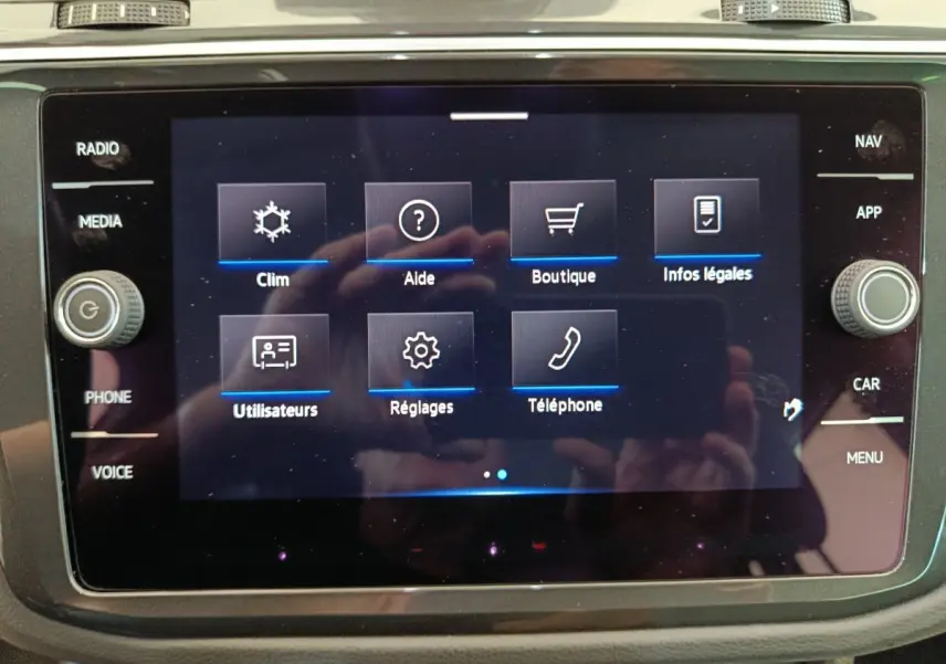 Écran tactile central du Volkswagen Tiguan 1.4 eHybrid 2022 affichant le menu principal avec options clim, aide et téléphone.