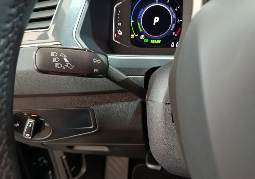 Détail du commodo gauche et du tableau de bord numérique du Volkswagen Tiguan hybride rechargeable bleu 2022.