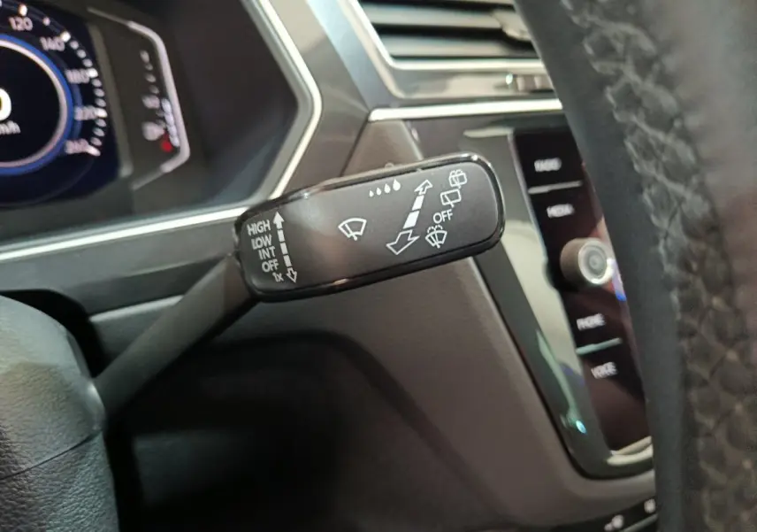 Gros plan sur la commande d’essuie-glace du Volkswagen Tiguan 1.4 eHybrid 2022, intérieur noir moderne.